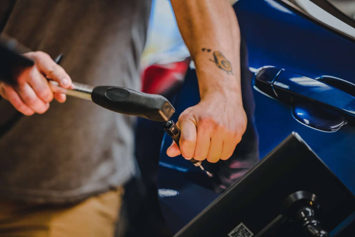 Student fixing dent on car door