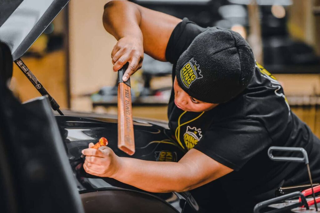 Student using The Ding King Dent Hammer to tap out a dent on a fender.