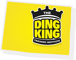 Logo of "the ding king paintless dent repair training institute" with a black crown on a yellow background, tilted with a white border and shadow effect.