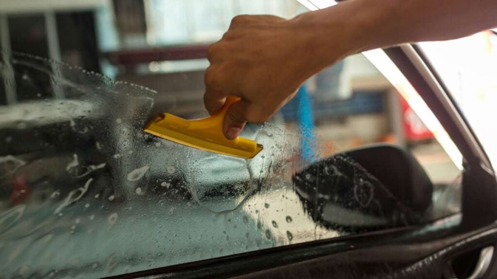 Technician Installing car window tint.