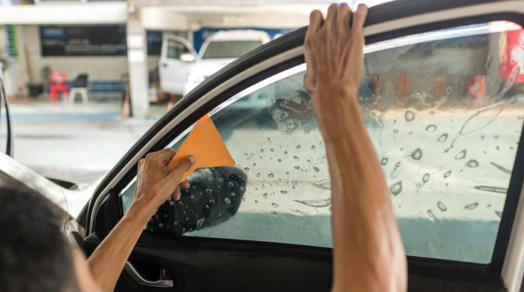 Technician Installing car window tint.